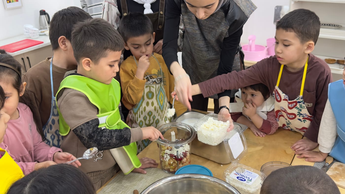 Murabbiy bilan birga ovqat tayyorlayotgan bolalar