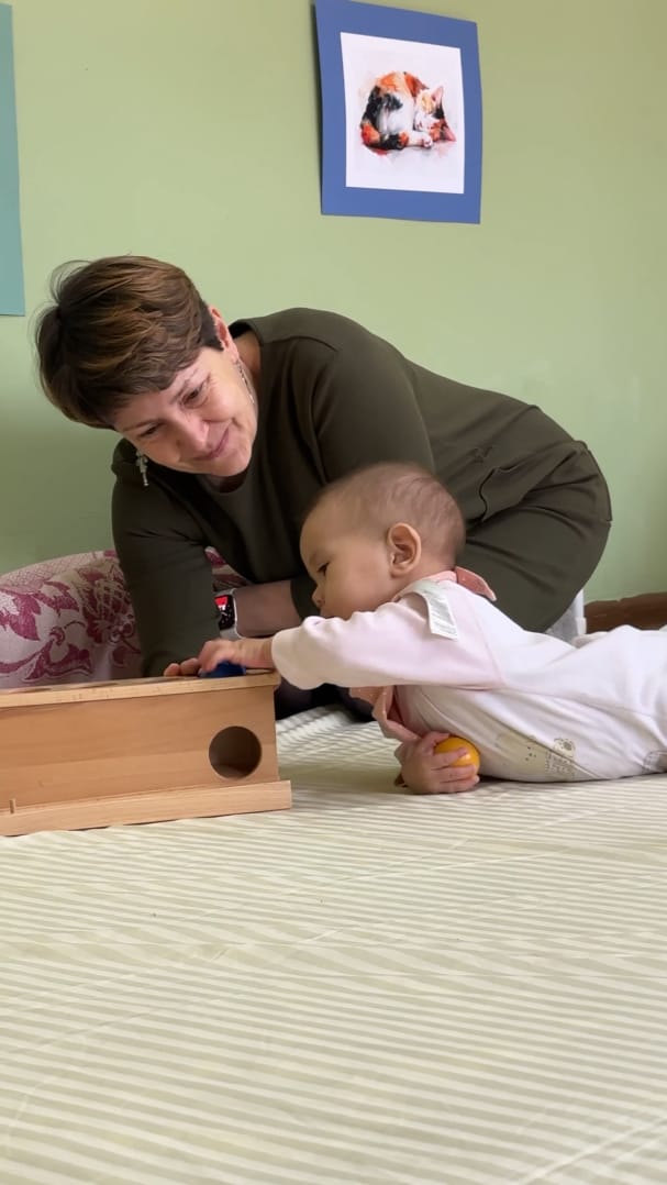 Nido muhitida yog'och quti bilan murabbiy va chaqaloq