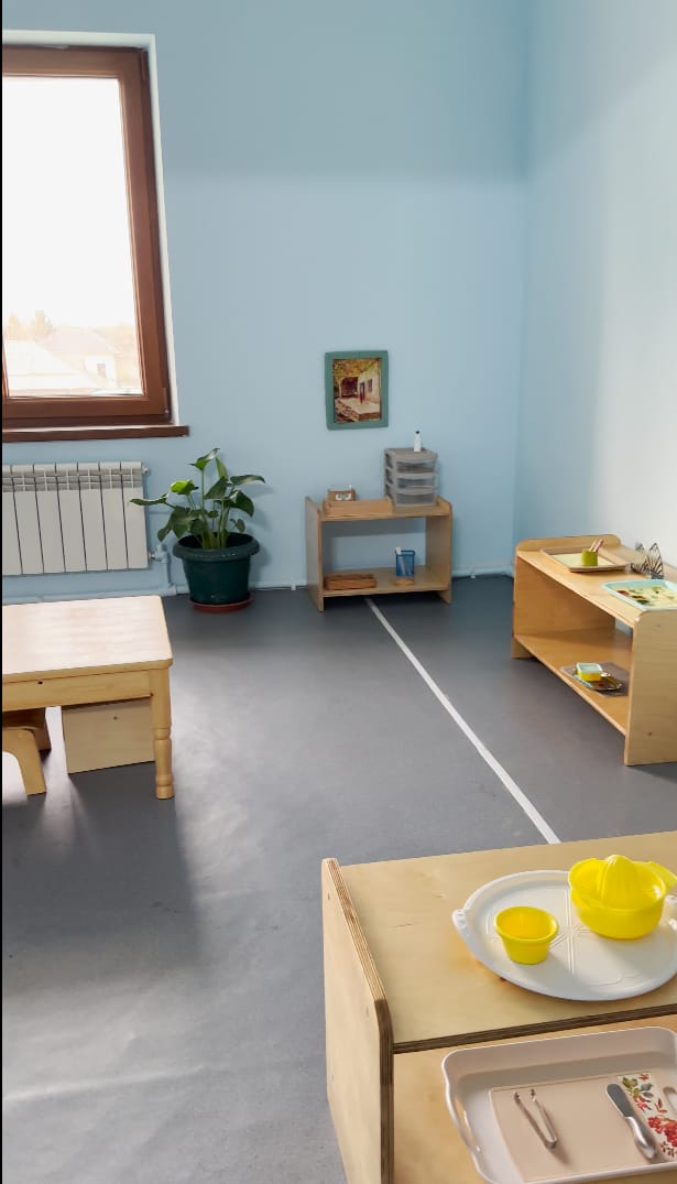 Past stollar va ish javonlari bo'lgan yorug' toddler sinfi